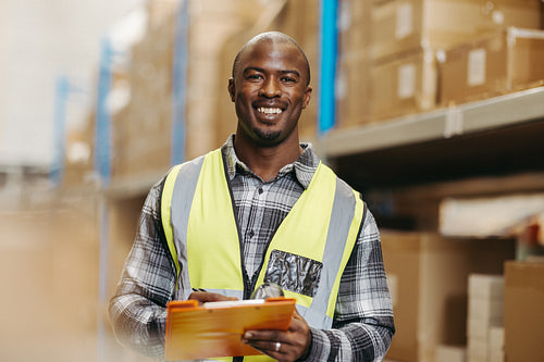 Cheerful warehouse manager smiling at the camera