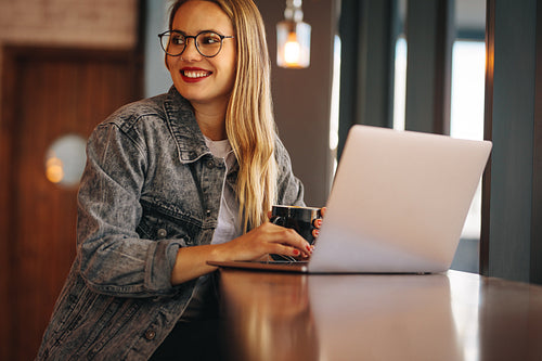 Happy woman at cafe with a laptop