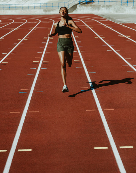 Woman runner training hard on a running track