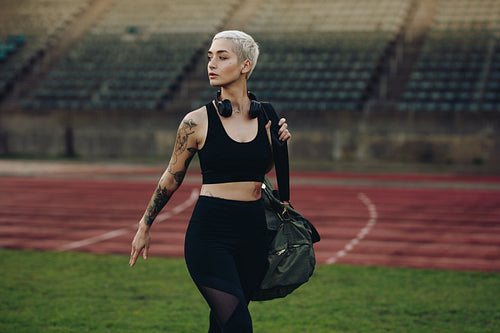 Woman athlete walking inside a track and field stadium
