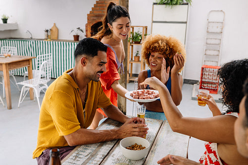 Friends enjoying snacks at a cheerful gathering in Rio de Janeiro