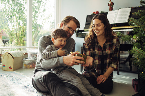 Parents giving Christmas gift to their son