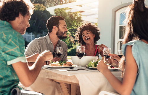 Friends having meal together outside their home