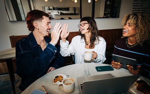 Friends sharing coffee and laughter at a cafe