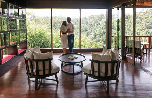 Couple in hotel room looking out the window