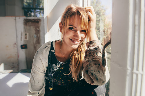Female painter sitting in her studio window