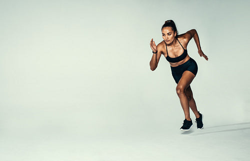 Hispanic female runner working out in studio