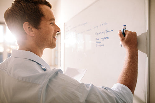 Man writing on whiteboard with marker pen