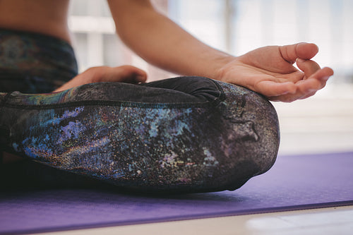 Woman meditating in Padmasana yoga pose at class