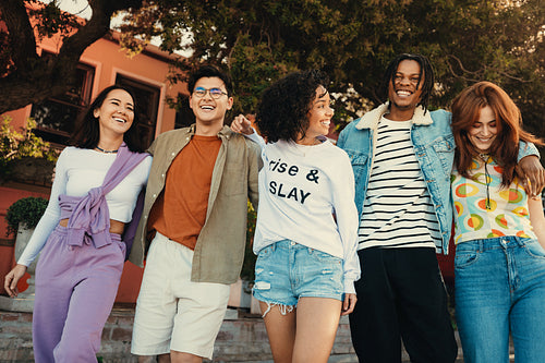 Group of friends enjoying summer day in the city, laughing and walking together