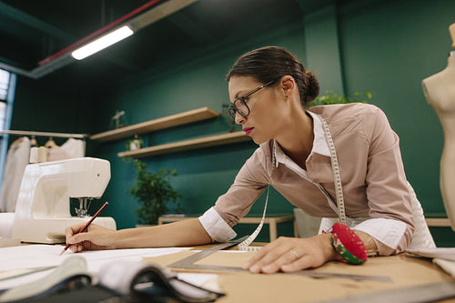 Fashion designer preparing design drafts on paper