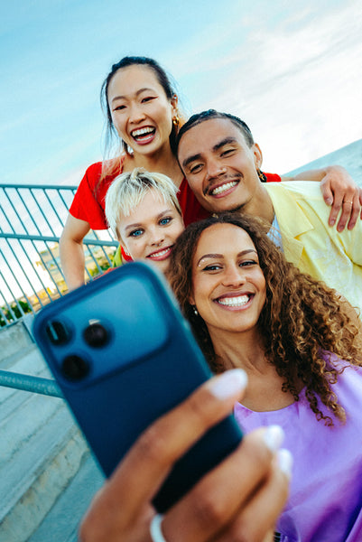 Group of friends taking a selfie outdoors during summer