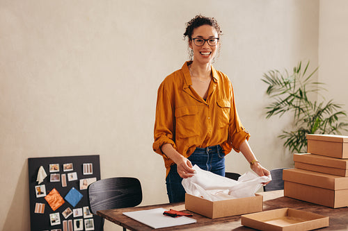 Woman packing parcel boxes for customers at home office