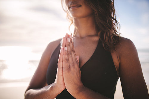 Woman practicing yoga meditation on the beach
