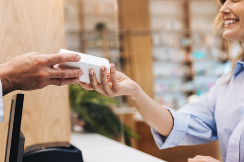 Pharmacist handing a patient a box of pills