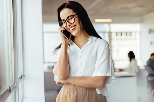 Happy business woman having a phone call in an office