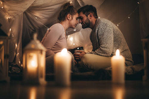 Couple sitting on bed in peace touching their foreheads