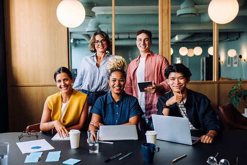 Group of colleagues smiling and working together in an office setting
