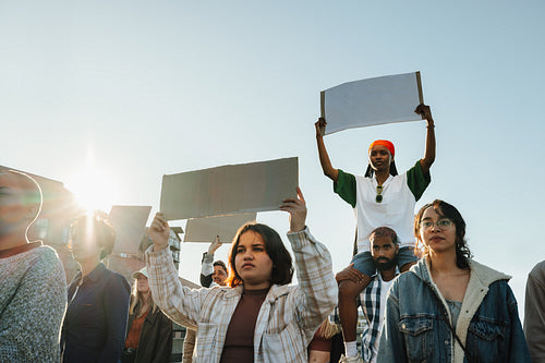 Group of activists holding blank signs during a protest on a sunny day