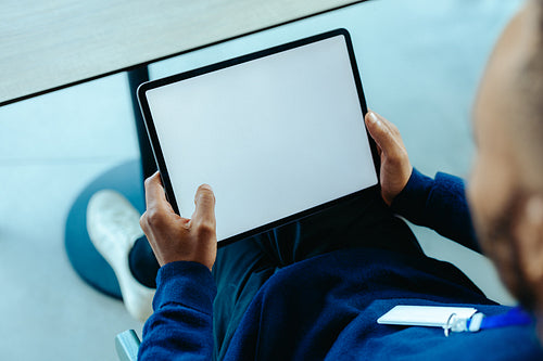 Person holding a tablet with empty copy space on the screen