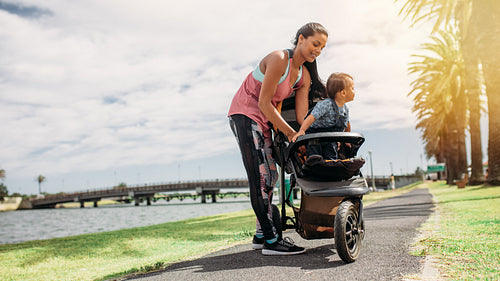 Mother placing her baby in a stroller
