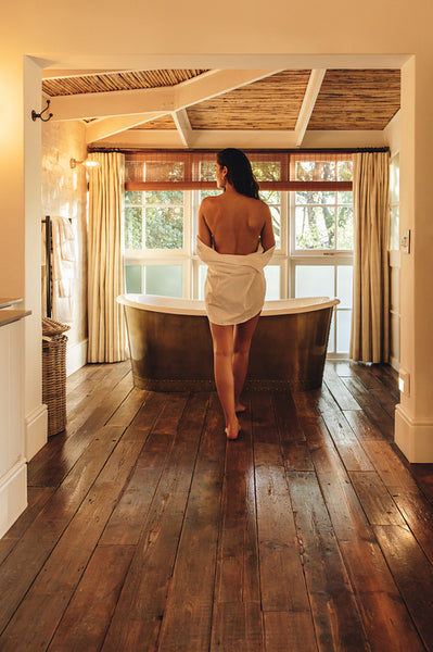 Young woman going to take a bath in a hotel room
