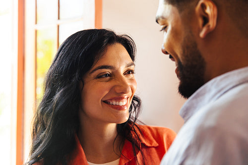 Smiling couple sharing a cheerful moment in bright natural light indoors