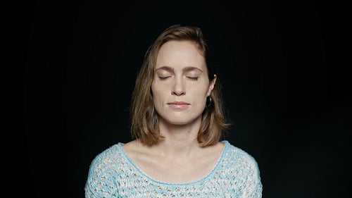  Woman standing with her eyes closed