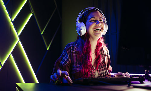 Female gamer laughing for joy, celebrating her victory in an online game