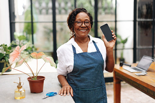 Senior woman recommending smartphone technology for entrepreneurship
