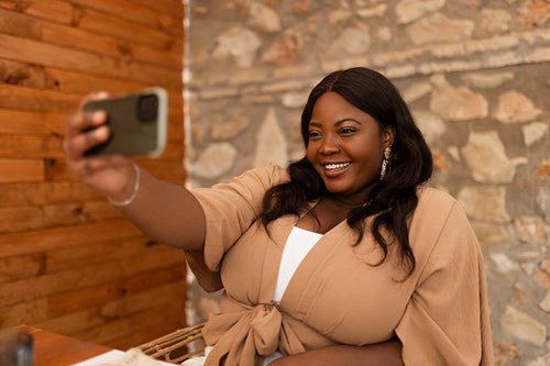 Happy young woman taking a selfie in a restaurant