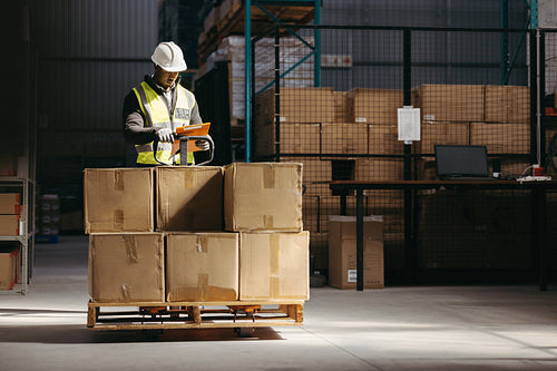 Warehouse employee reading a clipboard in a logistics centre