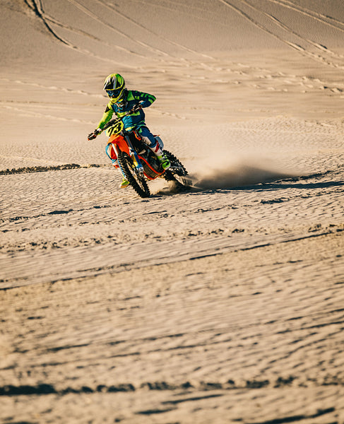 Motocross biker riding bike in the desert