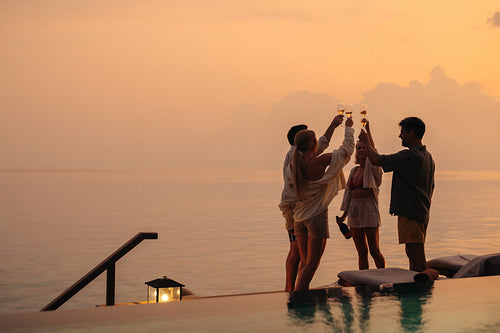 Raising a toast: Family on vacation by the sea, celebrating with champagne