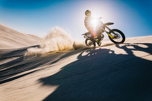 Motocross biker riding on sand dunes