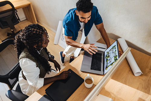 Young architects discussing modern house design at a bright office workspace