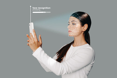 Face recognition system on smartphone. Woman scans her face to unlock her device