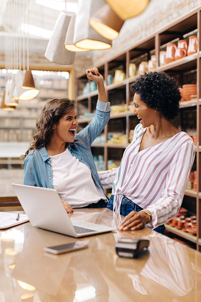 Female ceramists celebrating their success in their shop