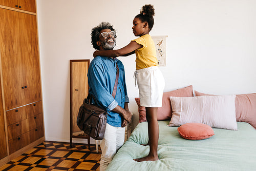 Man getting prepped for work by his young daughter