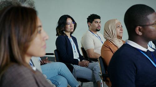 Diverse group of business professionals and attendees intently listening at a conference