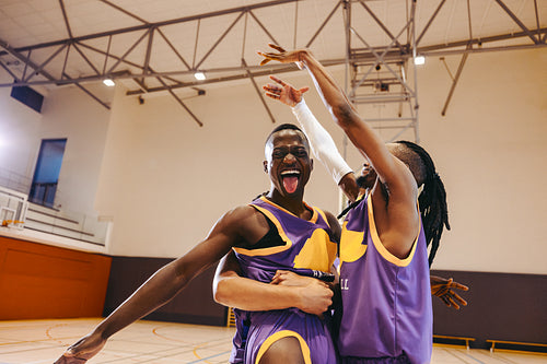 Teammates celebrating victory on basketball court