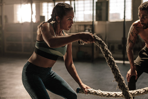 Female exercising with battle ropes