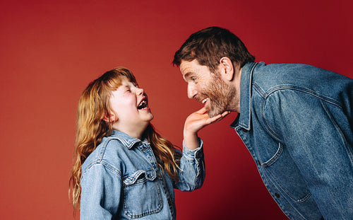 Laughing family joy fills the studio as a father and daughter face each other