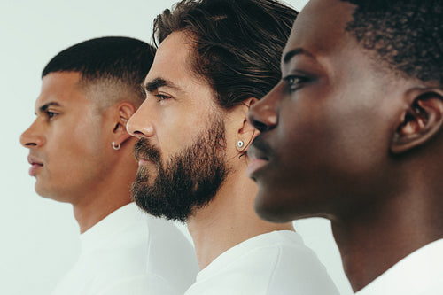Three men with diverse skin tones standing together in a studio, showing the results of a consistent skincare routine