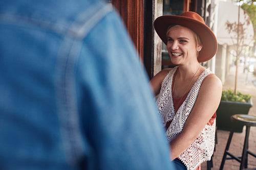 Smiling young woman sitting at a coffee shop with her friend