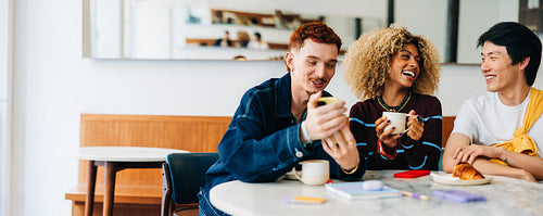 Friends enjoying coffee and laughter in casual meeting