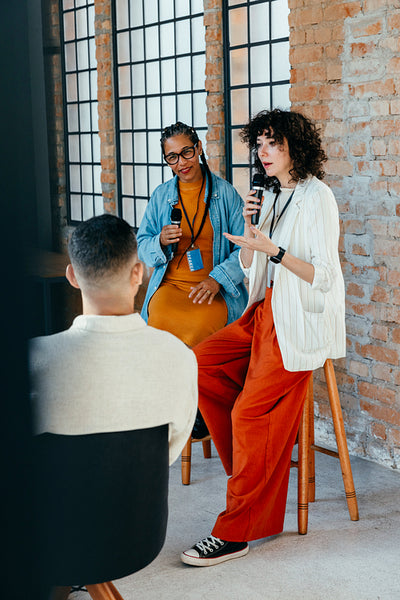Woman giving a presentation to employees in an office conference setting with attentive audience
