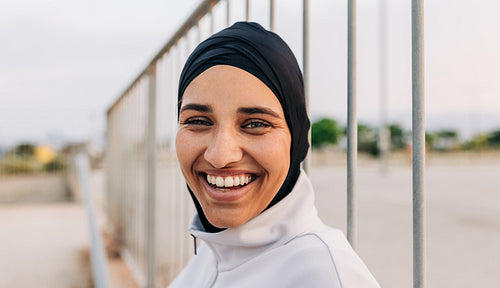 Happy Muslim woman smiling at the camera in sportswear