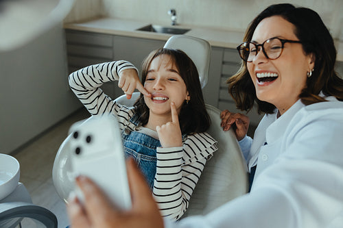 Happy dentist and child capture a selfie during dental clinic checkup