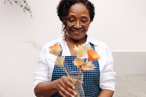 Happy business woman arranging handmade floral bouquet